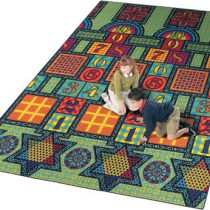 two kids playing on a large rug with hopscotch, checkers, tic-tac-toe, chinese checkers, and chess boards.