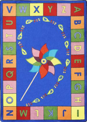 An educational kids rug with a pinwheel in the center and the alphabet around the edge.