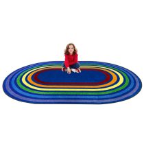 A child sitting on an oval kids rug with rainbow colored rings around the rug.